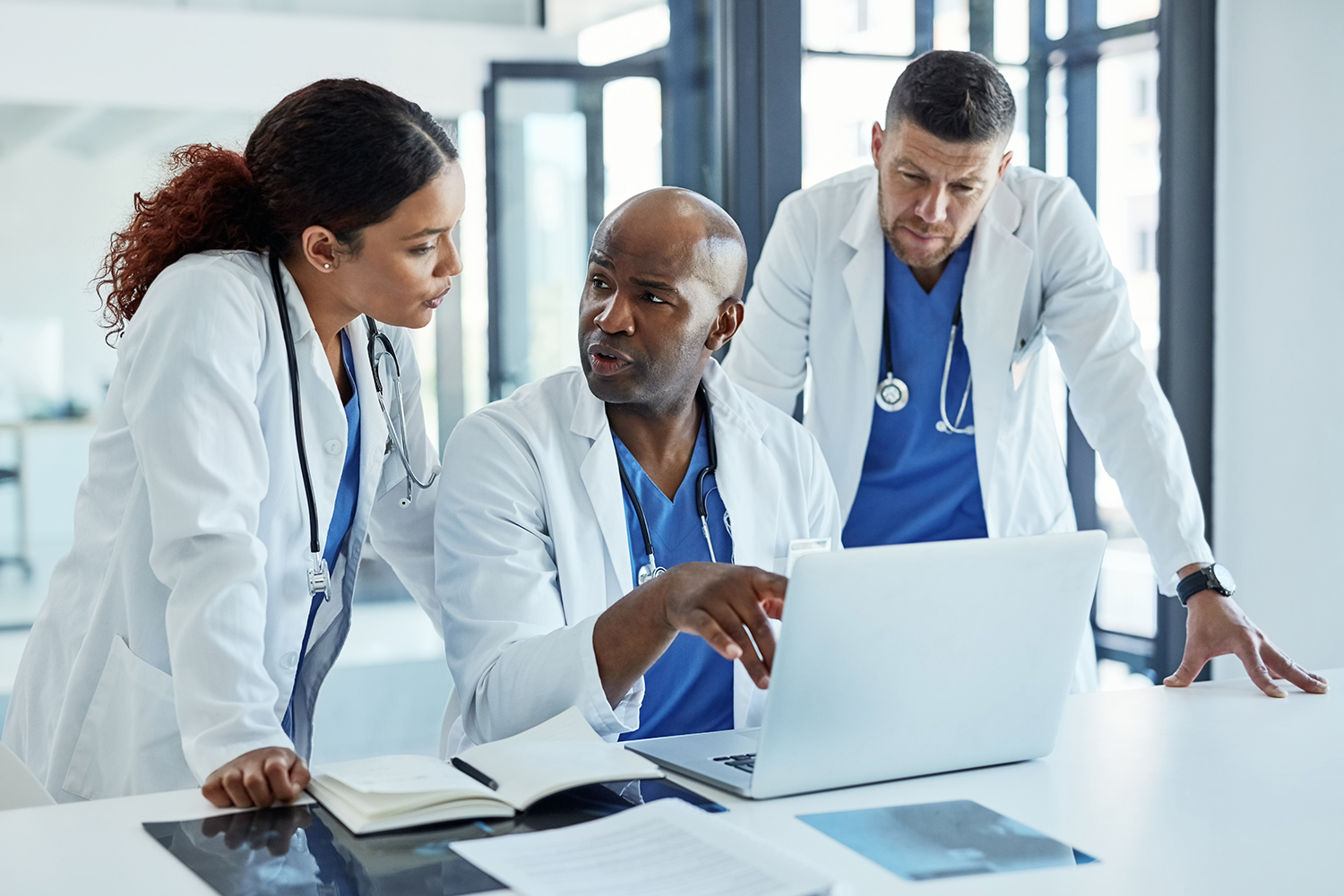 Três médicos analisando documentos em um escritório